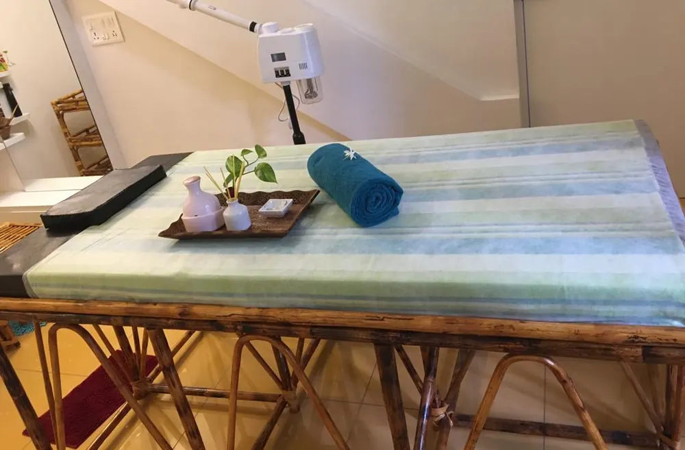 Massage bed with a rolled towel and oils ready